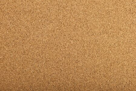 brown corkboard background texture with a fine grainの写真素材