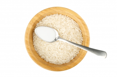 wood bowl with raw rice and spoon with salt isolated on whiteの写真素材