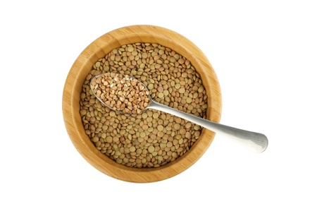 wood bowl with raw lentil and spoon with buckwheat isolated on whiteの写真素材
