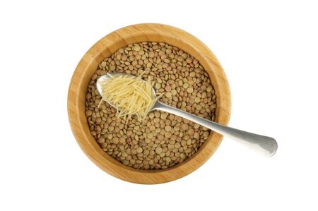 wood bowl with raw lentil and spoon with vermicelli isolated on whiteの写真素材