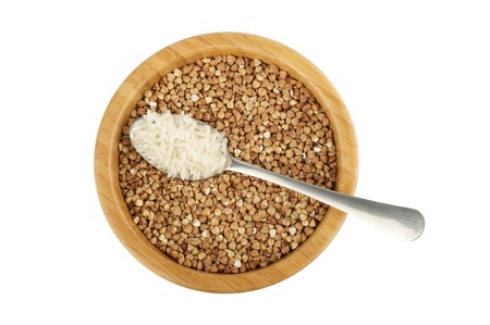 wood bowl with raw buckwheat and spoon with rice isolated on whiteの写真素材