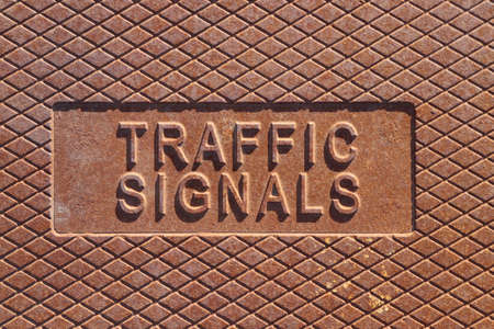 TRAFFIC text on rusty metal manhole coverの写真素材