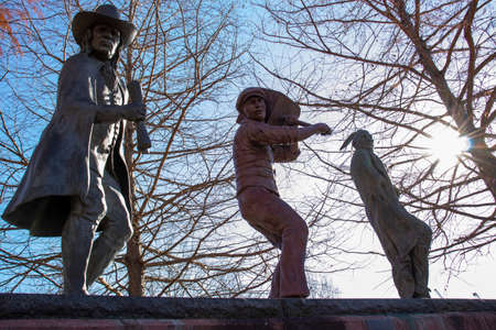 Statue of a man and a woman in the park against the background of blue skyの写真素材