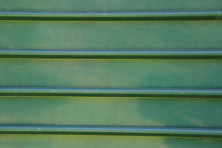 Green metal fence. Corrugated sheet of metal. Metal backgroundの写真素材