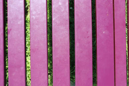 Pink wooden fence with grass in the background. Close-up.の写真素材