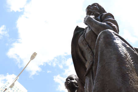 Statue of a woman on a background of blue sky with cloudsの写真素材