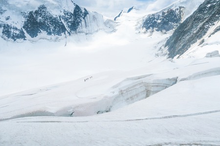 Mountain climbers walking on the glacier near the crack. View to the Mensu glacier. Belukha Mountain area. Altaiの写真素材