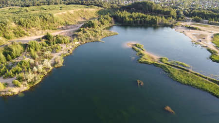 Flooded and overgrown sand quarry. Lush green summer landscape for outdoors vacation, hiking, camping or tourism. Volokolamsk district, Moscow region. Sychevo beach, Russiaの写真素材