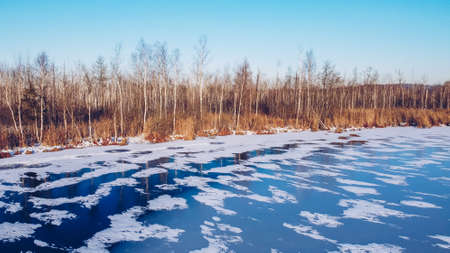 Frozen winter lake ice. Beautiful clear blue ice stock photography. Selective focus, blurred...