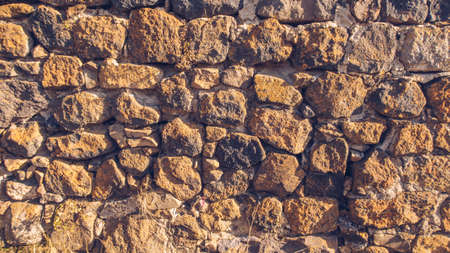 Antique natural stone wall. Old ruins pattern stock photo. Obsolete granite pattern background