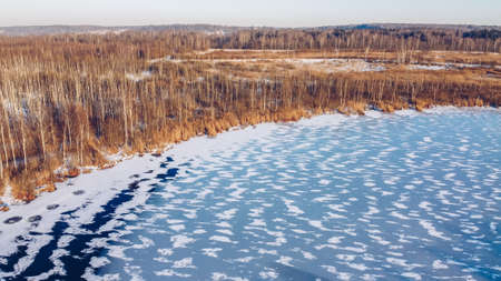 Frozen winter lake ice aerial view. Beautiful clear blue ice stock photography from bird's eye view. Selective focus, blurred background.の写真素材