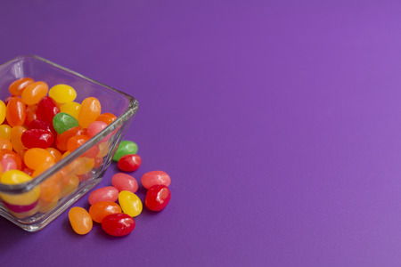 Colorful candies in candy on purple backgroundの写真素材