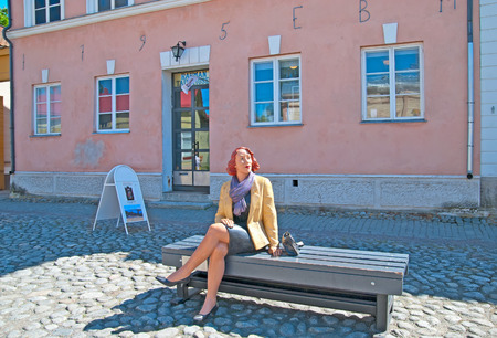 RAUMA, FINLAND - JULY 6, 2013: The sculpture of a woman sitting on the bench in front of the Art Museum in the old part of Rauma. Old Rauma is an object of the Unesco world heritage siteのeditorial素材