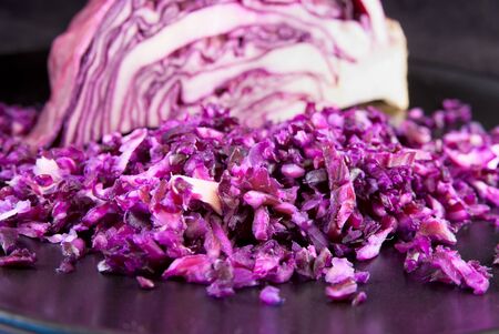 Finely chopped red cabbage with part of the head on the backgroundの写真素材