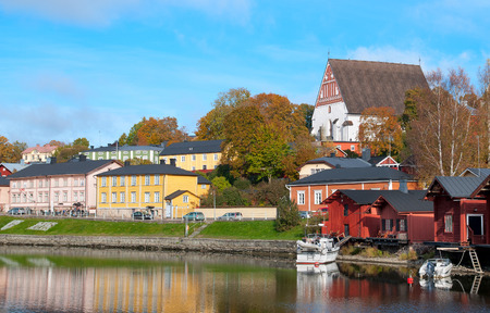 PORVOO, FINLAND - OCTOBER 18, 2015: The River Porvoonjoki Bank with the Old Red Storage Buildings and cafes. On the background is the City Cathedral. Autumn view.のeditorial素材