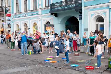 SAINT - PETERSBURG, RUSSIA - JUNE 20, 2016: Children blow giant soap bubbles outdoor near Griboyedov Channel not far from Nevsky Avenue in St Petersburgのeditorial素材