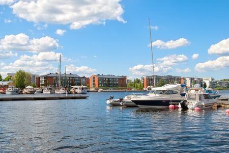 LAPPEENRANTA, FINLAND - JUNE 15, 2016: Pier with yachts and boats on Saimaa Lake. On the background are residential buildings on Rapasaari Islandのeditorial素材