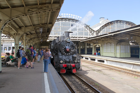SAINT - PETERSBURG, RUSSIA - JULY 10, 2016: Vitebsky Railway Station. People take pictures near coal retro-locomotive on the platform.のeditorial素材