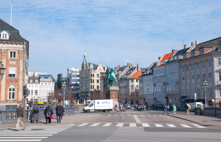 COPENHAGEN, DENMARK - APRIL 13, 2010: People walk on Hojbro Bridge over Slotsholmens Kanal (The Castle Islet Channel). On the background is The Hojbro Square (Hojbro Plads) with Bishop Absalon Statueのeditorial素材