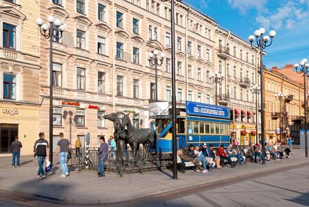 Saint-Petersburg, RussiaâJuly 7, 2019: People sitting on the benches near The Horsecar Monument with ticket office on 6-7 Lines Street of Vasilyevsky Island in the center of the cityのeditorial素材