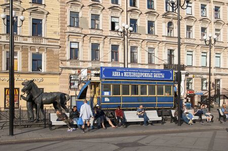 Saint-Petersburg, RussiaâJuly 7, 2019: People sitting on the benches near The Horsecar Monument with ticket office on 6-7 Lines Street of Vasilyevsky Island in the center of the cityのeditorial素材