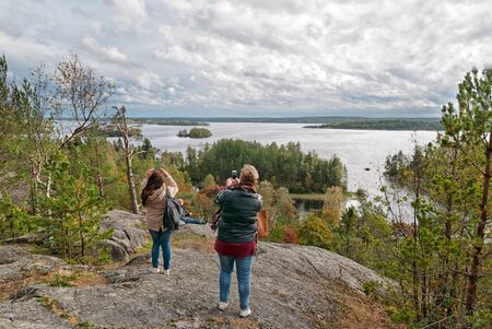Kilpola Island. Lakhdenpokhsky District. Republic of Karelia. Russia - September 22, 2018: People take pictures of Ladoga Lake from Rullalahdenvuori Rock in autumnのeditorial素材