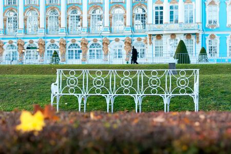 Tsarskoye Selo, Saint-Petersburg, Russia - October 15, 2019: White bench in the autumn Catherine Park in front of The Catherine Palace. The Tsarskoye Selo is State Museum-Preserveのeditorial素材