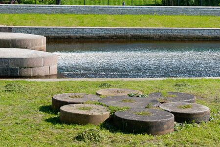 Saint-Petersburg, Russia â June 3, 2019: The hydro complex of the former Okhta Gunpowder Factory with a spillway zone and a dam bridge. Foreground is the millstones for grinding gunpowder massのeditorial素材