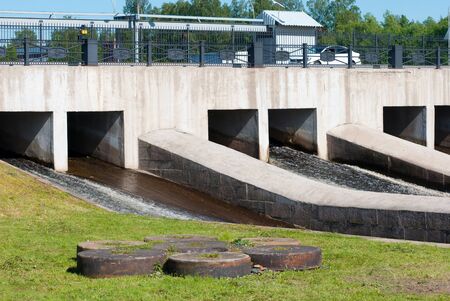 Saint-Petersburg, Russia â June 3, 2019: The hydro complex of the former Okhta Gunpowder Factory with a spillway zone and a dam bridge. Foreground is the millstones for grinding gunpowder massのeditorial素材