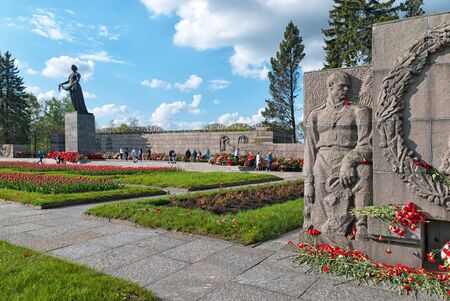 Saint-Petersburg, RussiaâMay 12, 2019: People are walking among flowers and wreaths near Mother Motherland Sculpture on Piskaryovskoye Memorial Cemeteryのeditorial素材
