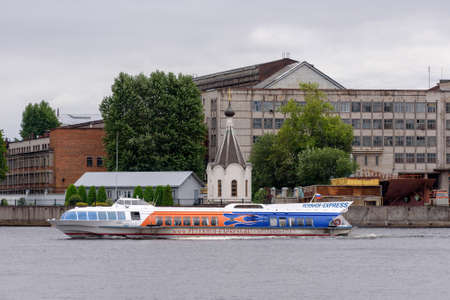 Saint-Petersburg, Russia - August 11, 2020: Hydrofoil tour boat sails past Saint Nicholas chapel and The Admiralty Shipyardのeditorial素材