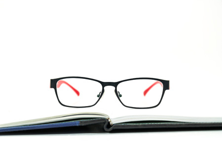 Glasses on a book on white backgroundの写真素材