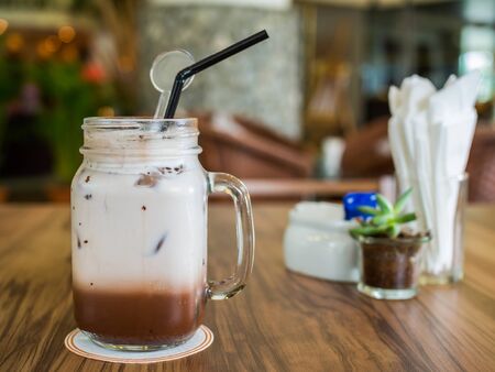Mug of cold chocolate on wooden tableの写真素材