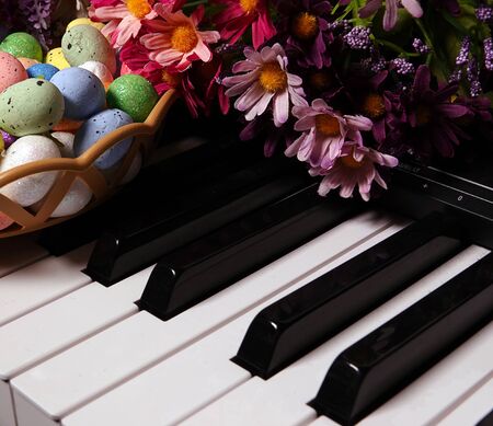Colorful Paschal Easter Eggs and Piano Keys and Flowers