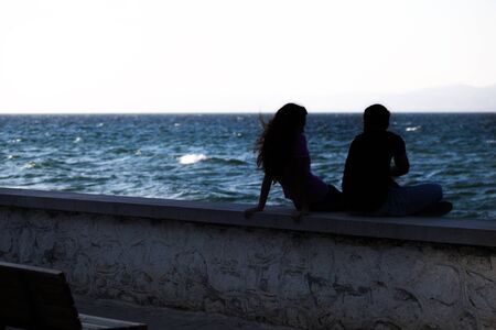 Young Couple Silhouette near the Seaside Photoの写真素材