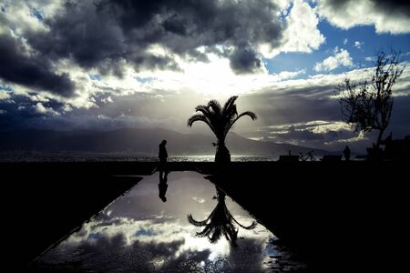 Seaside view and A Man Silhouette on the Water in the Groundの写真素材