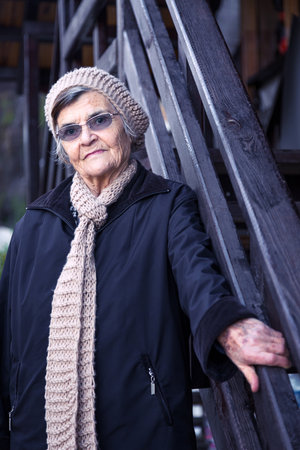 Portrait of an elderly woman in a hat and glasses on the streetの写真素材