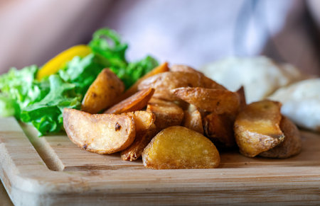 Food Fried Potato Wedges on a Wooden Plateの写真素材