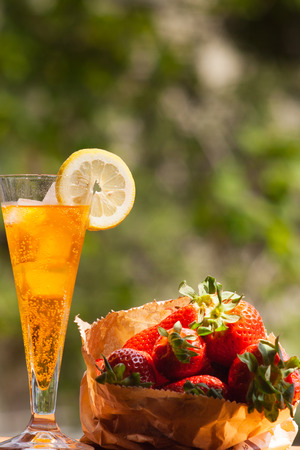 a chilled drink with fresh strawberries outdoorsの写真素材