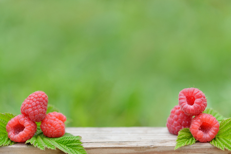 fresh raspberry on wooden table on natural blurred background