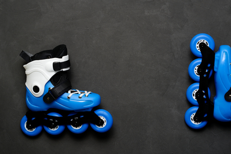 Blue roller skates on dark chalk board background. Street culture layout desk, flat lay space for text. I love skatingの写真素材