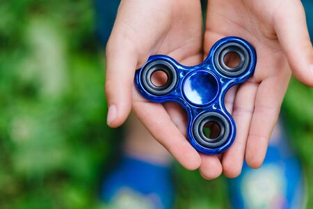 Close up view Teen boy playing a fidget spinner outdoorsの写真素材
