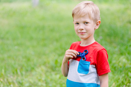 Teen boy playing a fidget spinner outdoorsの写真素材