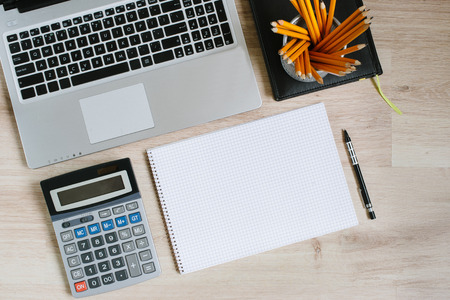 Work office desk table with laptop, tablet, supplies and calculator. Top view with copy space, flat...
