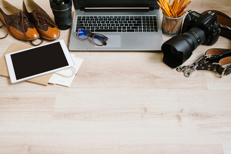 Photography hipster work table set with computer, tablet, film, lenses, supplies and camera. Top view with copy spaceの写真素材