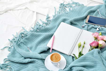 Flat lay tablet and flowers on white blanket with turquoise plaid. Window light, space for text blog, postsの写真素材