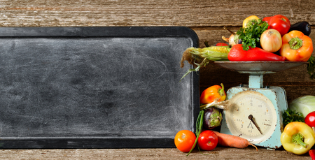 Banner composition of raw organic fresh vegetables, chalk board for text, balance on wooden brown table. Autumn harvest and organic foodの写真素材