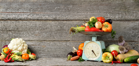 Banner composition of raw organic fresh vegetables, balance on wooden brown table. Autumn harvest and organic foodの写真素材