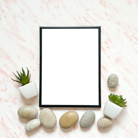 Flat lay marble desk with white empty frame for text, stones and succulents backgroundの写真素材