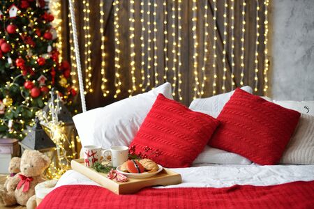 breakfast in bed, tray with cup of coffee and croissant. Modern bedroom interior. Romantic morning surprise. Christmas moodの写真素材